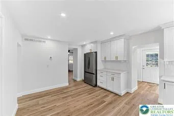 a view of a kitchen with a refrigerator and a sink