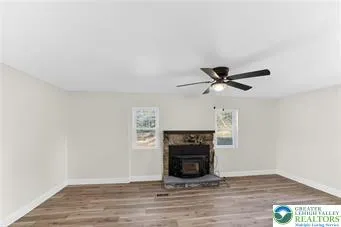a view of empty room with wooden floor and fireplace