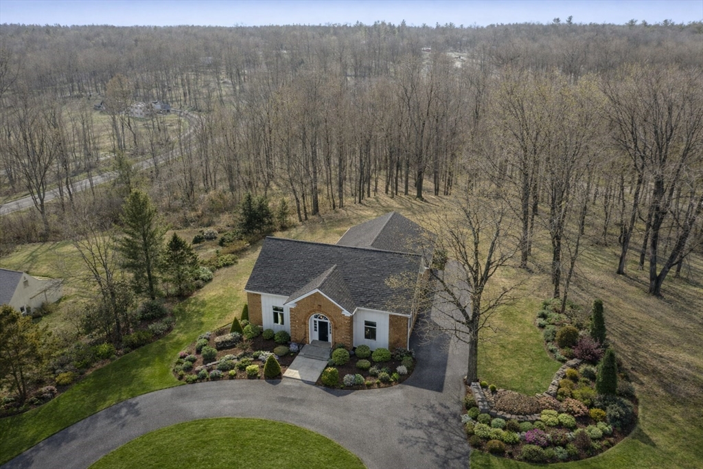 a front view of a house with a yard and large tree