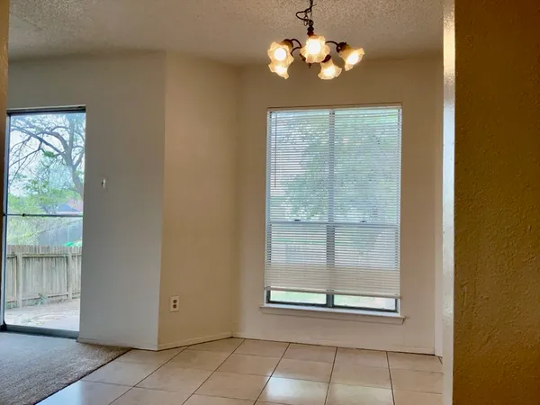 a view of a livingroom with a chandelier fan and window