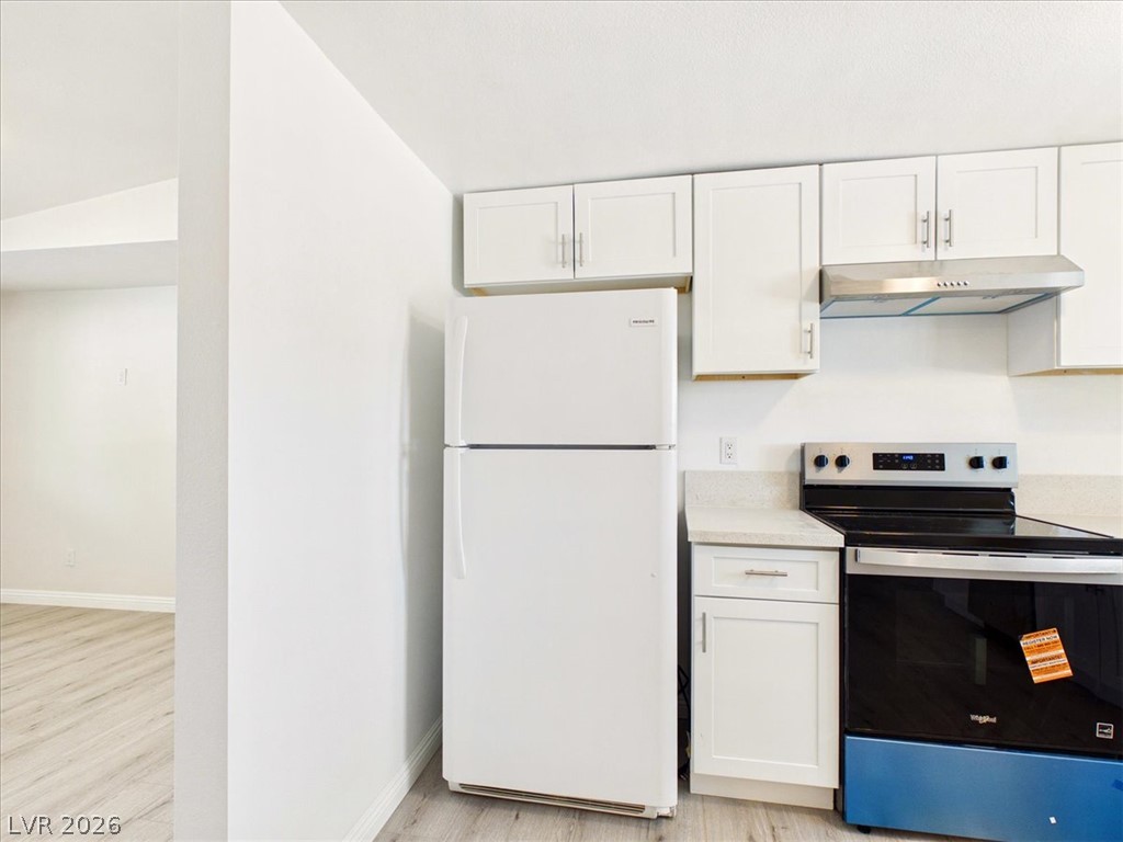 4081 Retread Road Pahrump, NV 89048 - Photo 23 of 98 A well-appointed kitchen features white cabinetry, stone countertops, and modern appliances, offering functionality and a polished aesthetic.