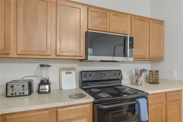 a kitchen with stainless steel appliances granite countertop white cabinets and a stove top oven