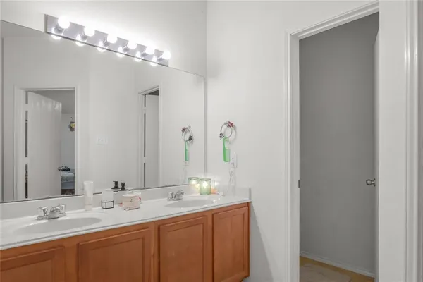 a bathroom with double vanity and a mirror