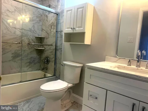 a bathroom with a granite countertop sink toilet and shower