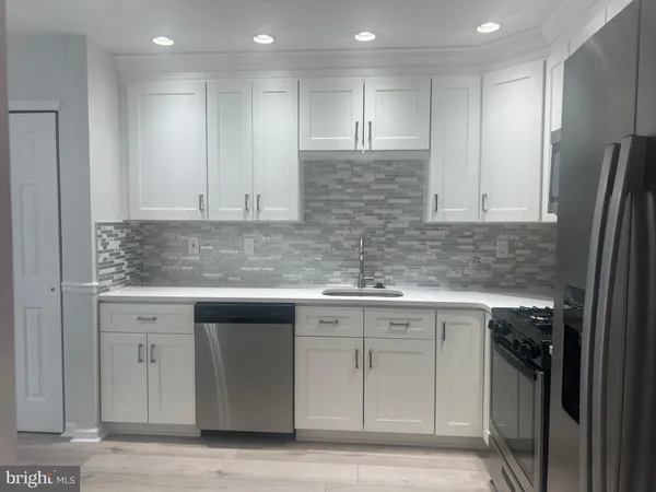 a kitchen with stainless steel appliances granite countertop a sink and a stove