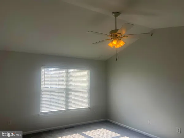 a view of an empty room with window and fan
