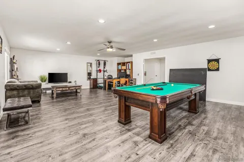 a room with wooden floor and pool table