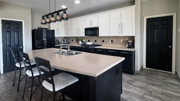 a kitchen with stainless steel appliances granite countertop a kitchen island a stove a table and a refrigerator