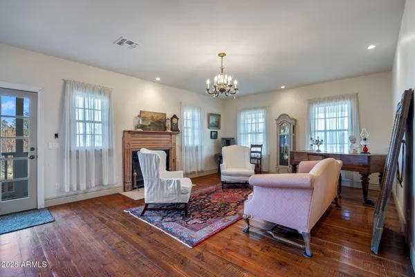 a kitchen with stainless steel appliances kitchen island granite countertop a refrigerator a stove top oven and a dining table with wooden floor