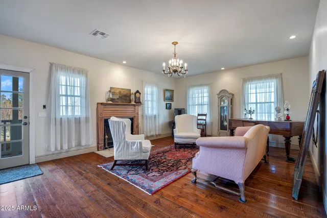 a kitchen with stainless steel appliances kitchen island granite countertop a refrigerator a stove top oven and a dining table with wooden floor