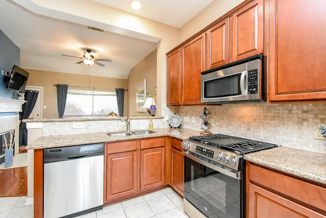 a kitchen with stainless steel appliances granite countertop a stove microwave and sink