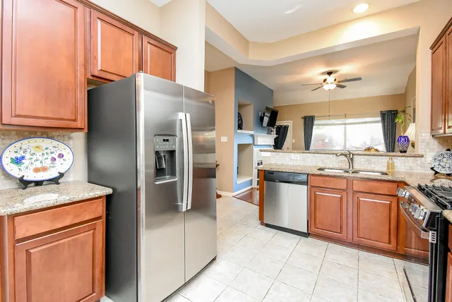 a kitchen with stainless steel appliances granite countertop a refrigerator a sink a stove and island