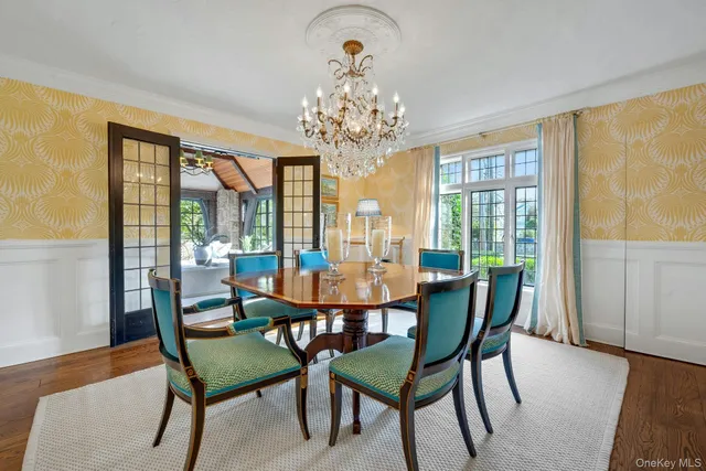 a view of a dining room with furniture a chandelier and wooden floor