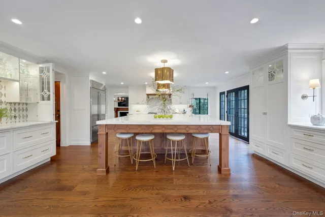 a dining room with wooden floor a chandelier a wooden table and chairs
