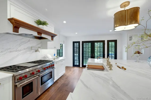 a large kitchen with stainless steel appliances granite countertop a stove and a window