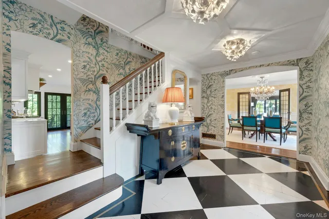 a room with lots of white furniture and a chandelier
