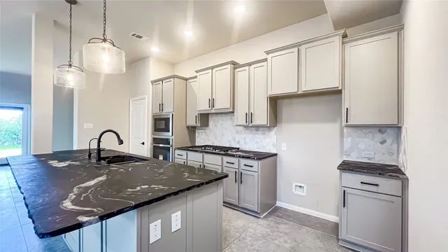 a kitchen with stainless steel appliances granite countertop a sink a stove and a refrigerator