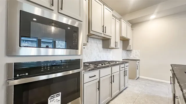 a kitchen with stainless steel appliances granite countertop a stove and a microwave