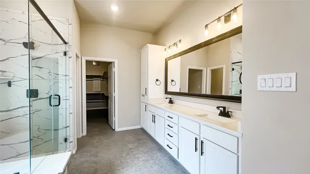 a bathroom with a double vanity sink mirror and shower