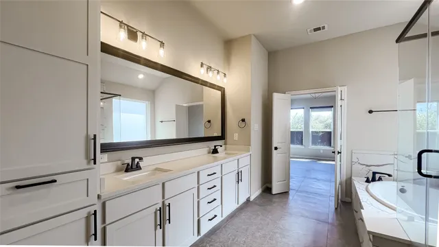 a spacious bathroom with double sink and a large mirror