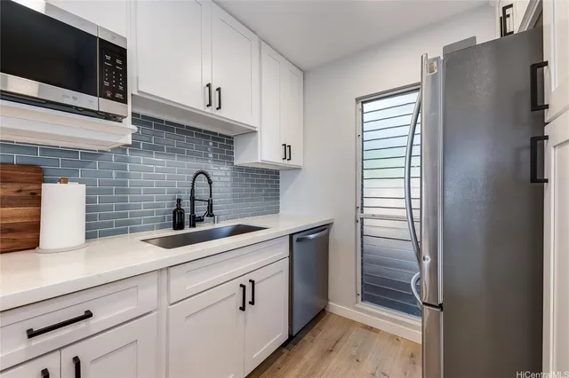 a kitchen with stainless steel appliances a sink and a refrigerator