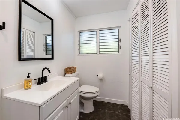 a bathroom with a toilet a sink and mirror