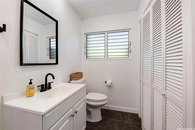 a bathroom with a toilet a sink and mirror