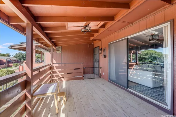 a view of a porch with wooden floor and furniture