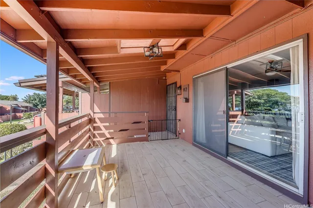 a view of a porch with wooden floor and furniture