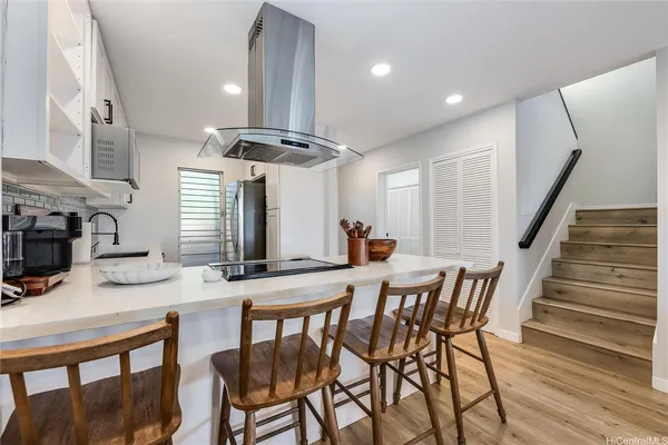 a kitchen with stainless steel appliances kitchen island granite countertop a kitchen island a stove a table and chairs