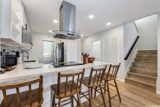 a kitchen with stainless steel appliances kitchen island granite countertop a kitchen island a stove a table and chairs