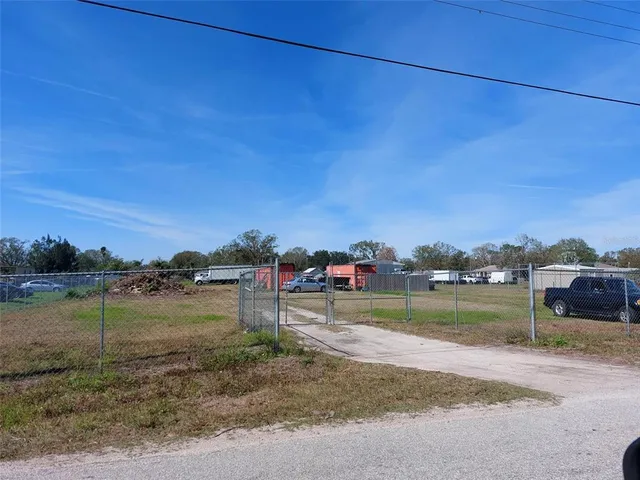 a view of a dry yard with wooden fence