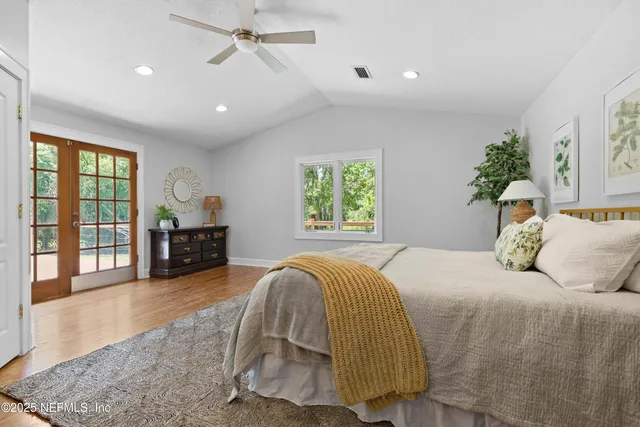 a bedroom with a bed and large windows