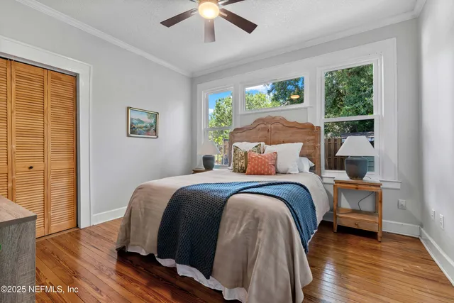a bedroom with a bed and wooden floor