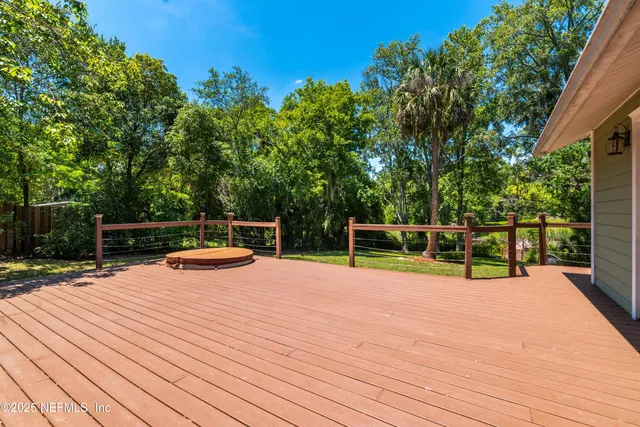 a view of a deck with chairs and wooden fence