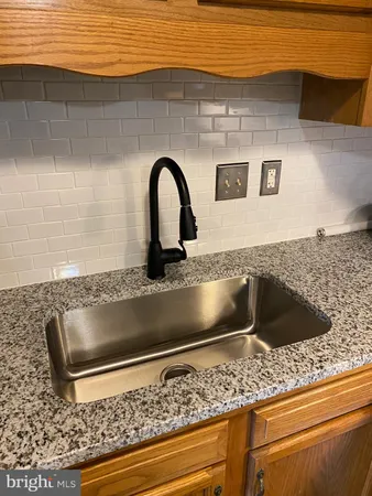a kitchen with stainless steel appliances granite countertop a refrigerator stove and sink
