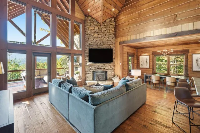 a living room with fireplace furniture and a floor to ceiling window