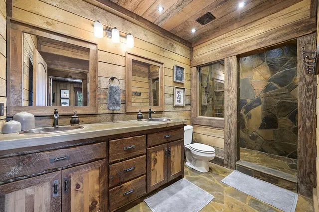 a spacious bathroom with a double vanity sink toilet and shower