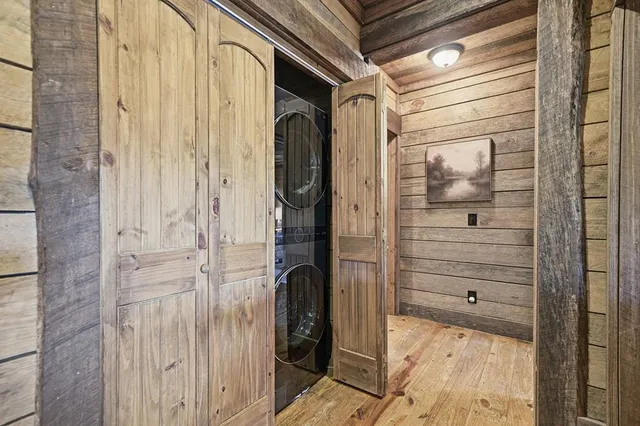 a view of a patio with table and chairs potted plants with wooden floor and floor to ceiling window