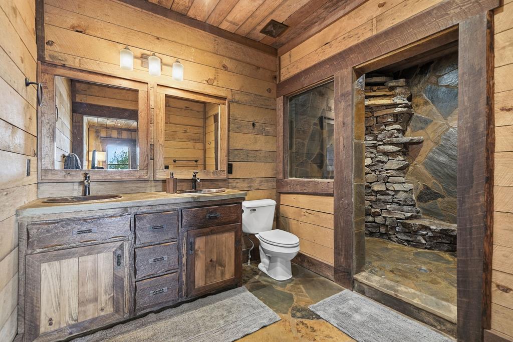 249 Settlement Road Epworth, GA 30541 - Photo 27 of 43 a bathroom with a granite countertop sink a toilet a mirror and shower