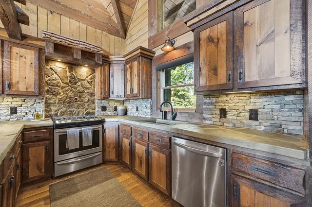 a kitchen with stainless steel appliances granite countertop a sink and a stove