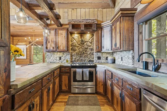a kitchen with stainless steel appliances granite countertop a sink and a stove