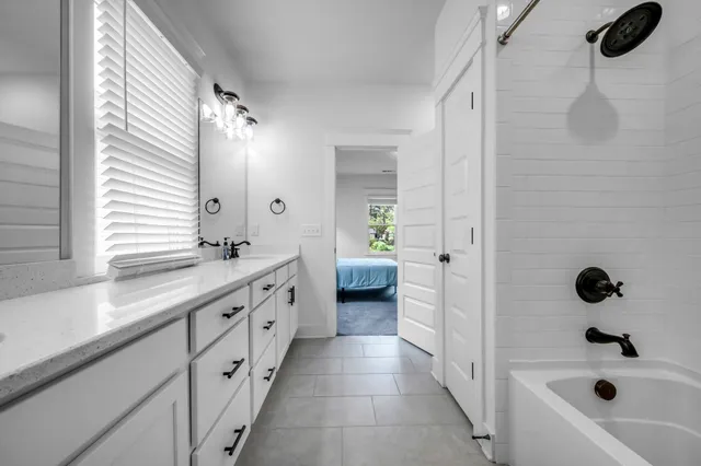 a spacious bathroom with a tub sink and mirror