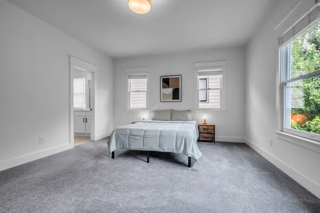 a spacious bedroom with a bed and a window