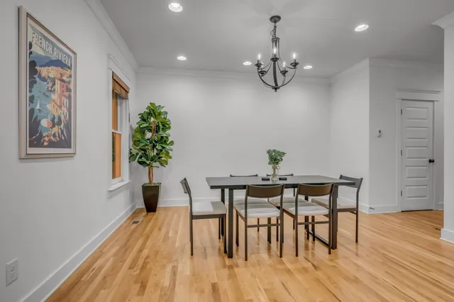 a view of a dining room with furniture wooden floor and chandelier