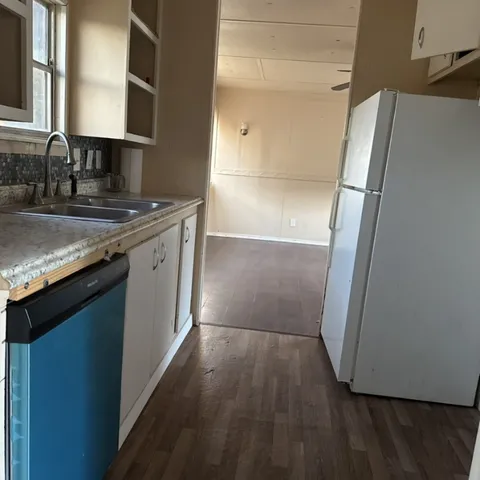 a kitchen with a refrigerator and a sink