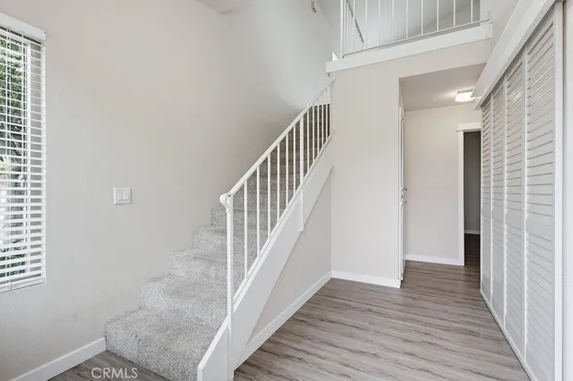 a view of a hallway with wooden floor and staircase