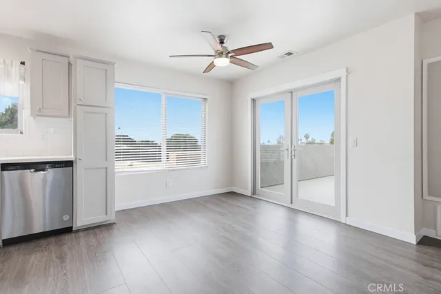 a view of an empty room with a window and wooden floor