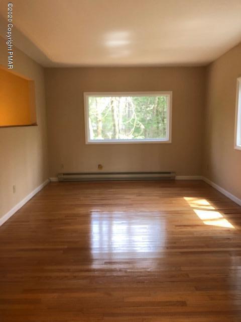 707 Dotters Corner Road Kunkletown, PA 18058 - Photo 7 of 18 an empty room with wooden floor and windows