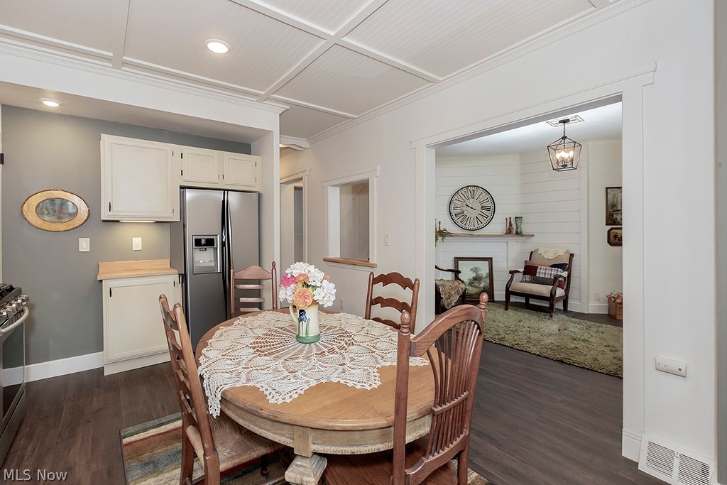 3090 Warren Road Cleveland, OH 44111 - Photo 10 of 50 Dining room with an inviting chandelier, coffered ceiling, and dark wood-type flooring